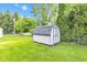 Wooden shed with a shingled roof in a yard with green grass and trees at 206 Cranberry Dr, Greenfield, IN 46140