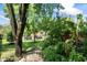 Backyard landscape with lush plants, decorative rocks, and a walkway leading towards the house at 2134 N Alabama St, Indianapolis, IN 46202