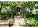 Charming home's front entrance with stone steps and lush landscaping, framed by mature trees at 2134 N Alabama St, Indianapolis, IN 46202