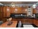 Traditional kitchen with wooden cabinets, black countertops, tiled backsplash, and stylish lighting at 2134 N Alabama St, Indianapolis, IN 46202