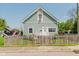 Charming home with light blue siding, white trim, and a fenced yard from across the street at 2230 Pleasant St, Indianapolis, IN 46203