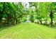 Spacious backyard featuring a large expanse of green grass, mature trees, and ample natural light at 2966 N Olney St, Indianapolis, IN 46218