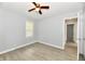 Neutral bedroom featuring wood-look floors, a ceiling fan, and a bright window at 2966 N Olney St, Indianapolis, IN 46218