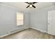 Bedroom with gray walls, wood-look flooring, ceiling fan, and window at 2966 N Olney St, Indianapolis, IN 46218