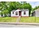 Charming small home with white siding, red trim, concrete steps, and a grassy front yard at 2966 N Olney St, Indianapolis, IN 46218