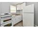 Functional kitchen featuring white appliances, white cabinets, and a stainless steel sink at 2966 N Olney St, Indianapolis, IN 46218