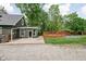Open backyard with patio, deck, playground, gravel, and lawn surrounded by mature trees providing ample shade at 31 N Bolton Ave, Indianapolis, IN 46219