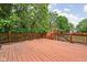 Large stained deck overlooking the backyard includes a slide and swing set and is surrounded by mature trees at 31 N Bolton Ave, Indianapolis, IN 46219