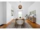 Bright dining room featuring hardwood floors, modern light fixture, and stylish decor with decorative shelving at 31 N Bolton Ave, Indianapolis, IN 46219