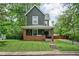 Charming two-story home featuring a welcoming front porch with a porch swing, landscaped yard, and classic architectural details at 31 N Bolton Ave, Indianapolis, IN 46219