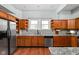 Bright kitchen featuring wood cabinets, granite countertops, stainless appliances, and wood floor at 31 N Bolton Ave, Indianapolis, IN 46219