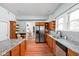 Kitchen with wood cabinets, granite countertops, stainless appliances, and hardwood floors at 31 N Bolton Ave, Indianapolis, IN 46219