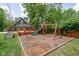 Backyard featuring wooden playground with slides and swings, deck, surrounded by mature trees and a privacy fence at 31 N Bolton Ave, Indianapolis, IN 46219