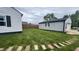 Well-maintained backyard featuring a lush lawn, detached garage, and partial privacy fence at 3324 S Walnut St, Muncie, IN 47302