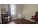 Cozy bedroom with hardwood floors and a window featuring a computer desk and red chair at 3324 S Walnut St, Muncie, IN 47302