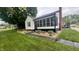 Landscaped front yard and exterior view showing the home's screened in porch and brick chimney at 3324 S Walnut St, Muncie, IN 47302