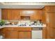 Functional kitchen features wooden cabinets, a stainless steel sink, and white appliances at 3537 Woodglen Way, Anderson, IN 46011