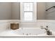 Close-up view of a luxurious tub area with a window, decorative accents, and a serene ambiance at 4130 N Meridian St, Indianapolis, IN 46208