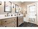 Bathroom featuring a double vanity with wooden cabinets, stylish mirrors, and modern fixtures at 4130 N Meridian St, Indianapolis, IN 46208