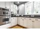 Kitchen showcasing stainless steel appliances, white cabinets, gas stove and natural light at 4130 N Meridian St, Indianapolis, IN 46208