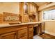 Basement kitchenette with wooden cabinets, a white countertop, and an electric stovetop at 4130 N Meridian St, Indianapolis, IN 46208
