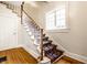 Elegant staircase with a patterned runner and a bright window, showcasing classic design at 4130 N Meridian St, Indianapolis, IN 46208