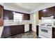 Kitchen featuring wood cabinets, white backsplash, double basin sink, and standard appliances at 4197 E 250 S, Franklin, IN 46131