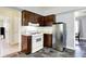 Kitchen featuring tile backsplash, white appliances, and dark wooden cabinetry at 4197 E 250 S, Franklin, IN 46131
