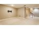 Finished basement with neutral carpeting, wall-mounted TV bracket, and staircase access at 4332 Heyward Pl, Indianapolis, IN 46250