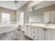Bright bathroom with double sinks, soaking tub, and modern gray wood floors for a spa-like experience at 4332 Heyward Pl, Indianapolis, IN 46250