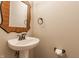 Stylish half bathroom featuring a pedestal sink, decorative mirror, and modern fixtures at 4332 Heyward Pl, Indianapolis, IN 46250