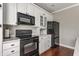 Functional kitchen featuring black appliances, ample white cabinets, and a minimalist design at 4332 Heyward Pl, Indianapolis, IN 46250