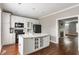 Open kitchen featuring a white island, black appliances, and hardwood floors flowing seamlessly to the living area at 4332 Heyward Pl, Indianapolis, IN 46250