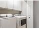 Well-lit laundry room with modern washer and dryer units, plus overhead cabinets at 4332 Heyward Pl, Indianapolis, IN 46250