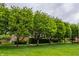 Street view with manicured green lawn and mature trees in front of the red brick townhomes at 4332 Heyward Pl, Indianapolis, IN 46250