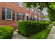 Brick townhouse with black shutters, manicured bushes and a sidewalk in front of the homes at 4332 Heyward Pl, Indianapolis, IN 46250