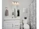 Small bathroom with white vanity, toilet, and a shower with grey patterned shower curtain at 5020 Eldon Dr, Noblesville, IN 46062