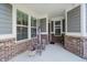 Cozy front porch featuring large windows, brick pillars, and a welcome sign for a warm, inviting entrance at 5020 Eldon Dr, Noblesville, IN 46062