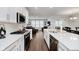 Bright kitchen boasts white cabinets and a view into the living room with hardwood flooring at 5020 Eldon Dr, Noblesville, IN 46062