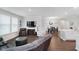 Spacious living room with hardwood floors, a large TV, and an open layout to the dining area and kitchen at 5020 Eldon Dr, Noblesville, IN 46062