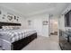 Bright main bedroom featuring tray ceiling, ensuite bathroom, and attractive dark furnishings at 5020 Eldon Dr, Noblesville, IN 46062