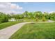 Sidewalk running along the edge of a pond with a fountain and surrounded by lush greenery at 5020 Eldon Dr, Noblesville, IN 46062