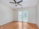 An open bedroom with hardwood floors and a ceiling fan, leading to a private outdoor patio at 5083 Emmert Dr, Indianapolis, IN 46221