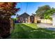 A lush green backyard offers a serene escape with a quaint patio, privacy fence, and vibrant trees for added shade at 5428 E 10Th St, Indianapolis, IN 46219