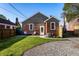 A cozy brick house shows an inviting backyard with a manicured lawn, providing a tranquil outdoor living space at 5428 E 10Th St, Indianapolis, IN 46219