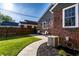 A well manicured backyard featuring manicured lawn, patio with seating, and well maintained brick exterior at 5428 E 10Th St, Indianapolis, IN 46219