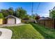 The property features a lush, green backyard with a detached garage and wood fence, offering privacy at 5428 E 10Th St, Indianapolis, IN 46219