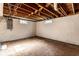 The basement has painted walls and ceiling, with an unfinished floor, and two small windows on the far wall at 5428 E 10Th St, Indianapolis, IN 46219