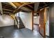 The basement stairs are visible along with an open closet and painted floor, and exposed duct work overhead at 5428 E 10Th St, Indianapolis, IN 46219
