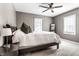 This is a carpeted bedroom featuring a ceiling fan, two windows, and a neatly made bed with a nightstand on the side at 5428 E 10Th St, Indianapolis, IN 46219